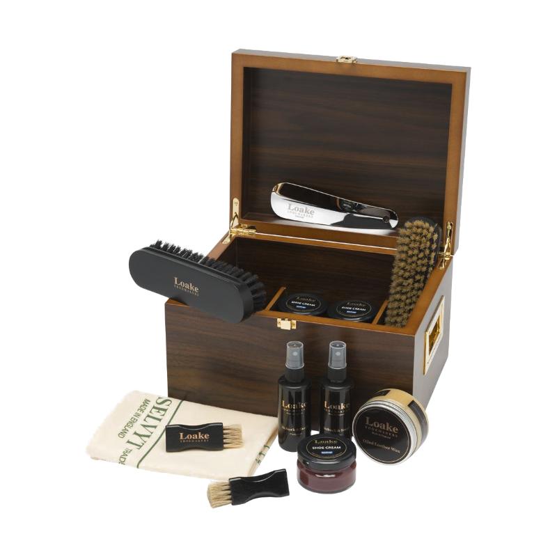 Wooden shoe care kit with various items including brushes and bottles on a white background